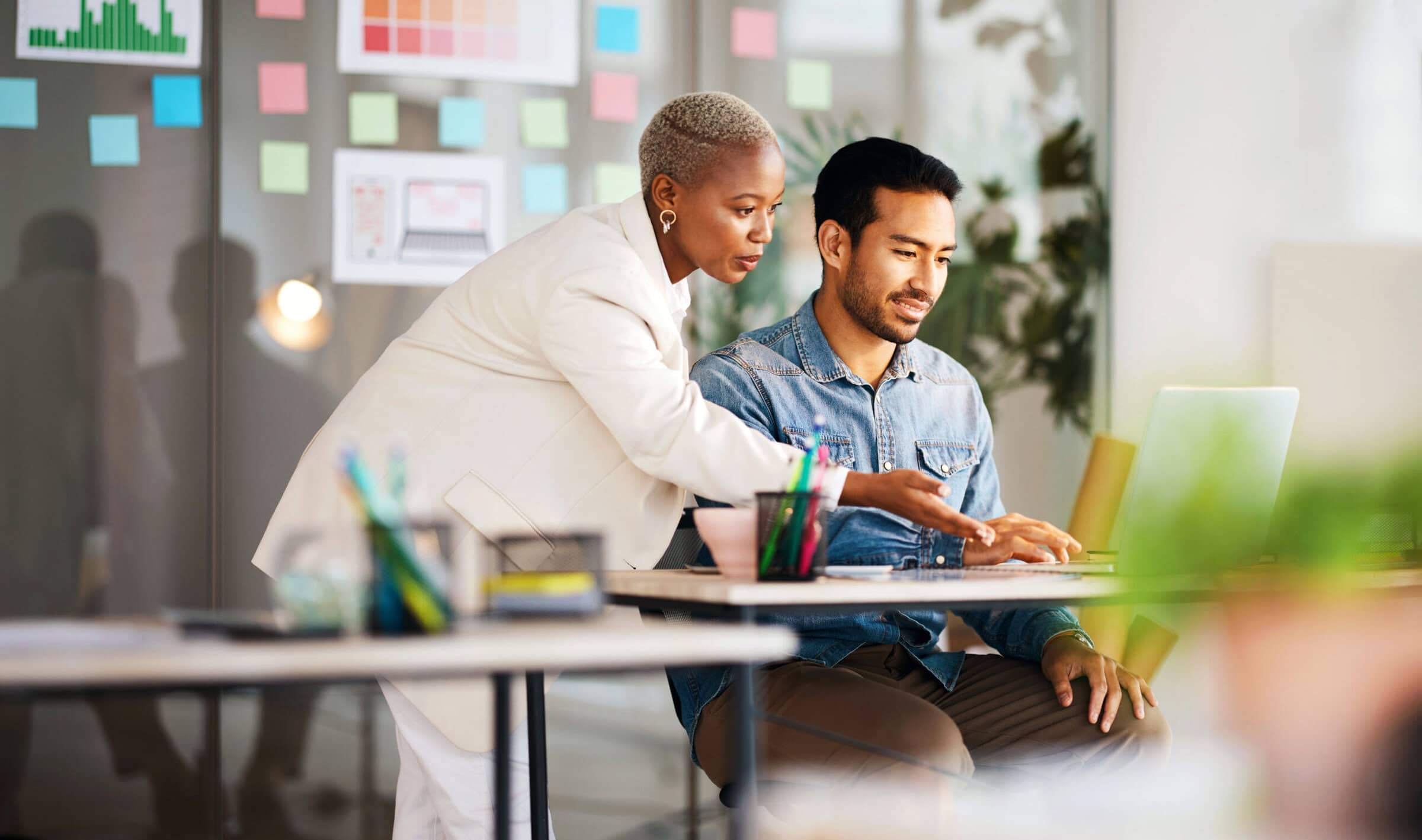 Supervisor helping intern employee at a computer