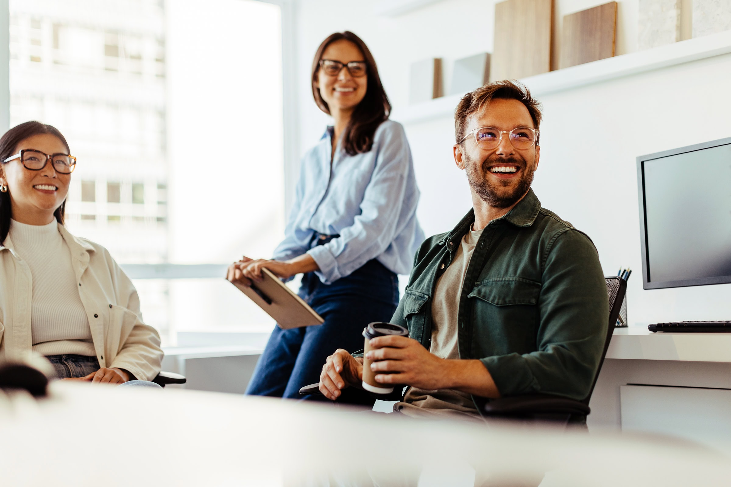 small-team-meeting-listening Professionals listening to a discussion in an office. Group of happy business people having a team meeting.