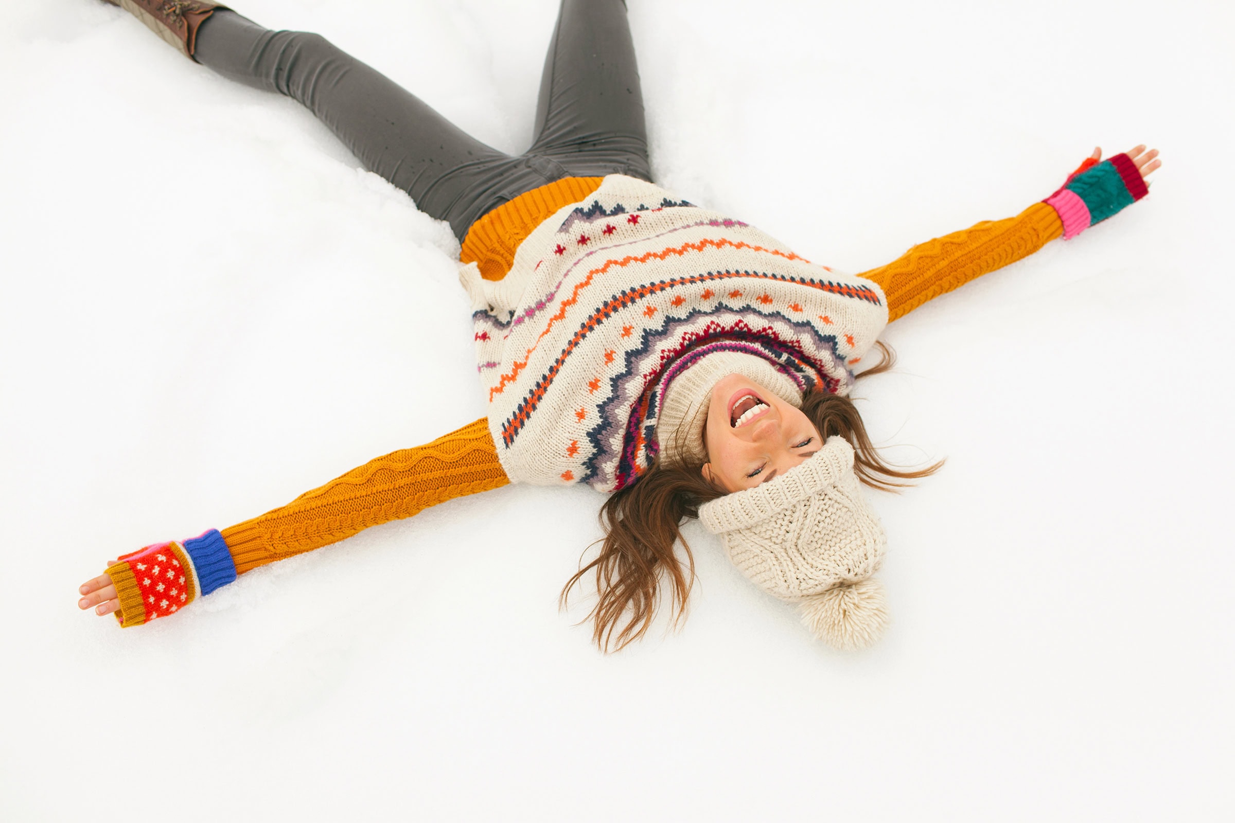 Carefree young woman making snow angel