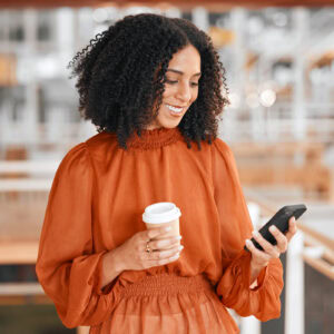 Reading notification, coffee and woman with a phone at work for social media, email check or internet. Smile, break and young corporate employee on a mobile app and a drink in an office for business.