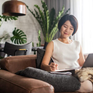 Happy woman using the computer at home to take an online continuing education course.