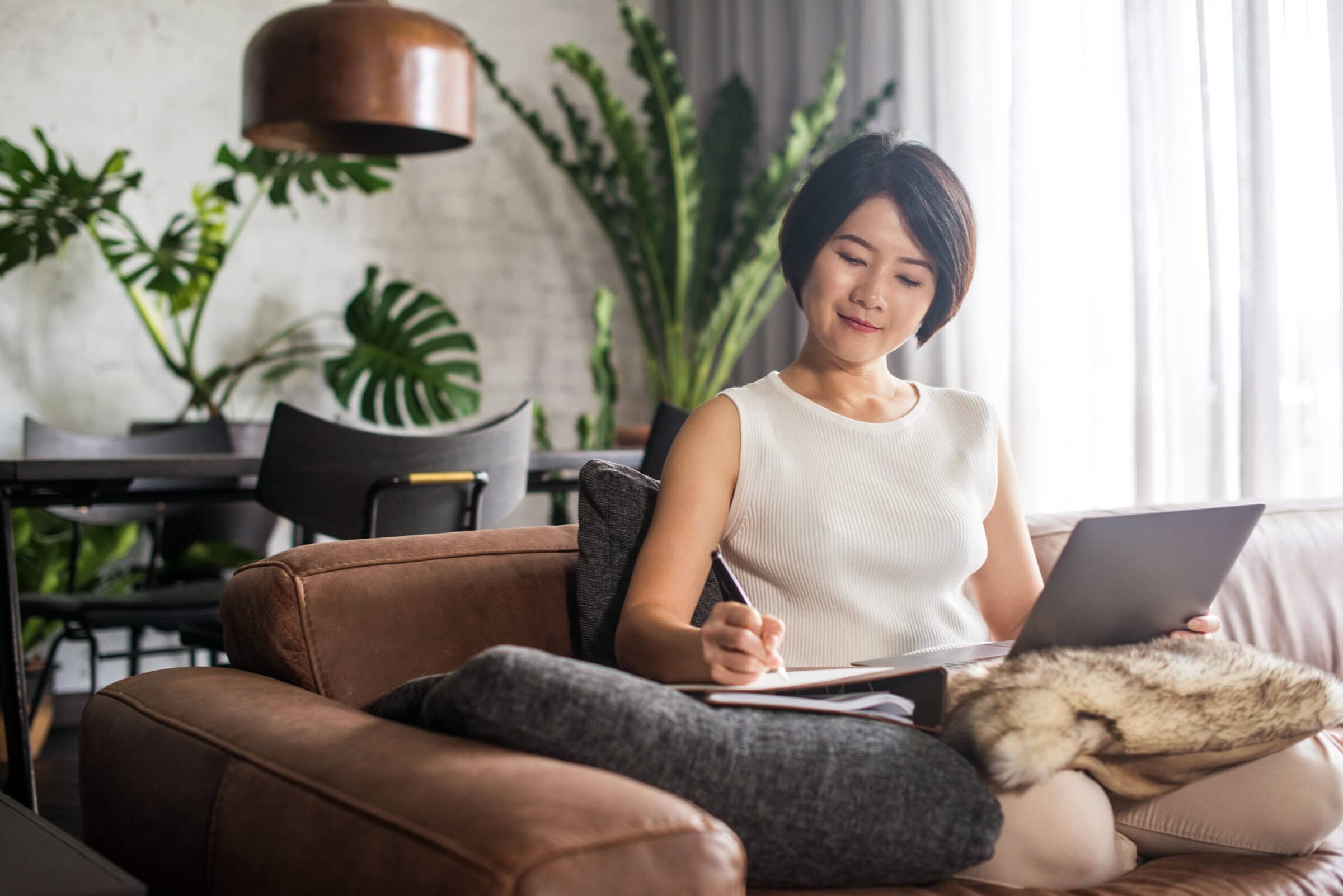 Happy woman using the computer at home to take an online continuing education course.