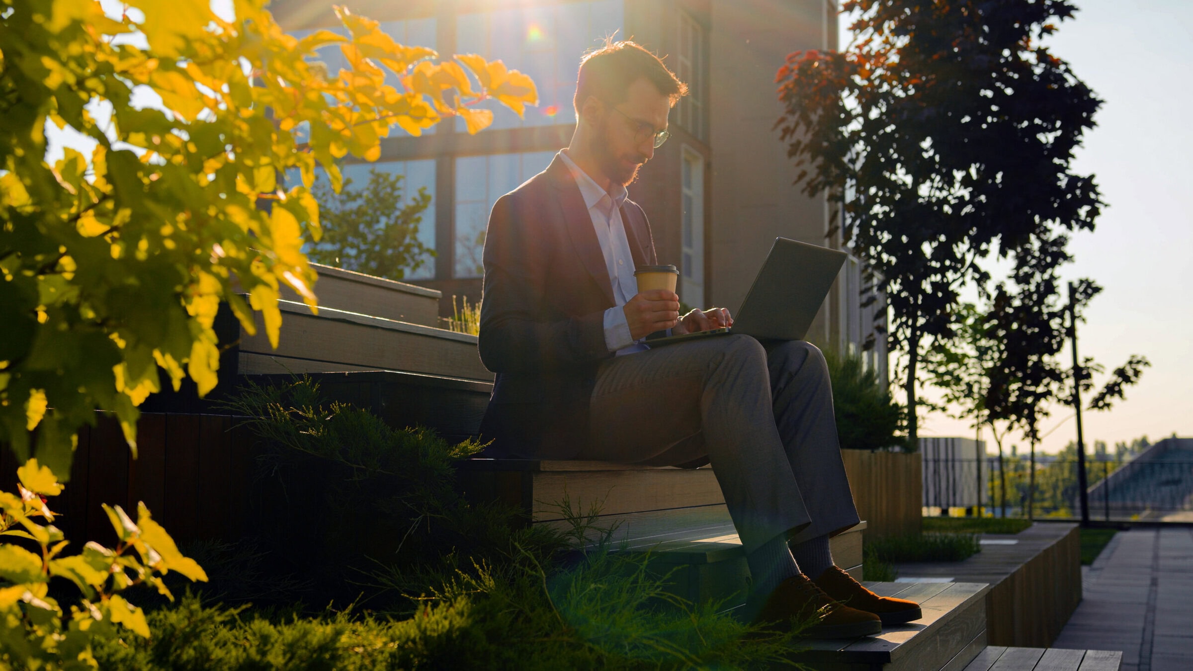 Business man working with laptop computer outdoor steps.