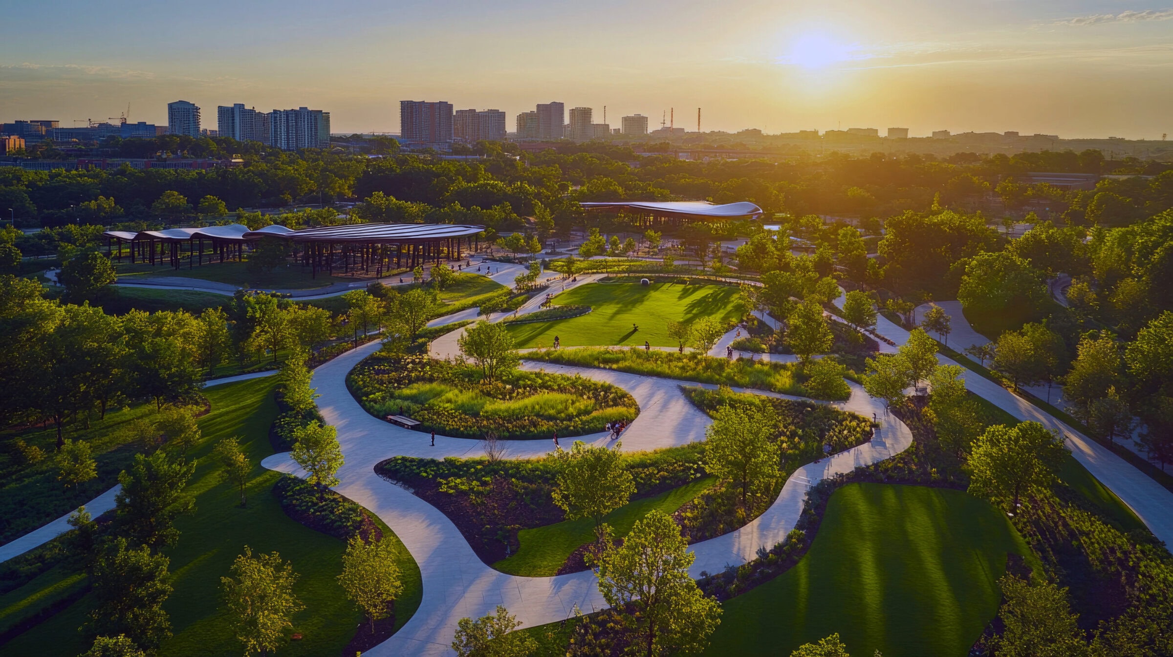 Scenic park at sunset, aerial view, winding paths, green landscape