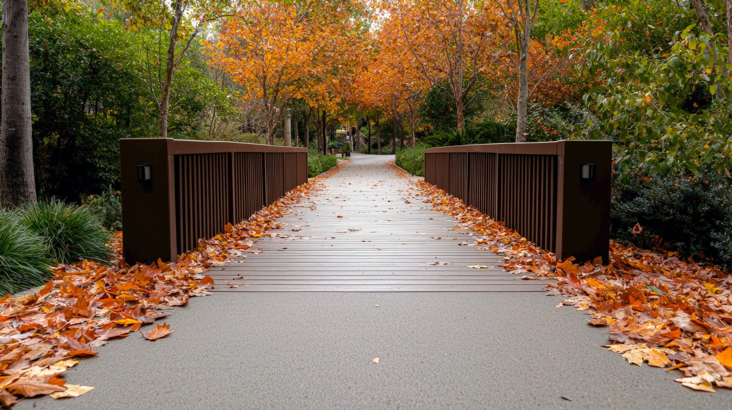 A peaceful autumn bridge lined with fallen leaves, surrounded by